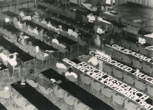 Conference staff is being given instructions, while the big letters for the stage decorations are visible on the table. 
(IAEA Archives/Credit: Photo Ellinger)