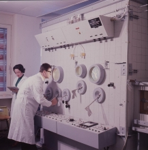 Hans Grasmuk and Olga Milosevic-Golwig, staff members, in front of the hot cell used for the remote handling of radioisotopes at the IAEA laboratory in Seibersdorf. April 1964. Please credit IAEA