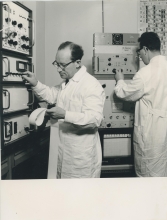 Turning a knob on the 512-channel gamma spectrometer donated to the laboratory by Finland, is Otto Suschny, head of the Environmental Radioactivity Section. The new instrument makes possible the simultaneous and rapid determination of several radionuclides in up to four samples at a time and will help save time analysing samples for scientific and health protection purposes.  In the background: Herbert Frittum, IAEA staff member.  April 1964. Please credit IAEA 