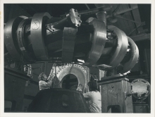 One of 24 magnetic coils being moved into position on the CLEO device at Culham Laboratory to produce a stellarator configuration.
The field from these coils with the field produced by currents flowing through the helical conductors around the torus (in the foreground) provides the confining magnetic field for high temperature plasma.
(IAEA Archives/Credit: UKAEA, United Kingdom)