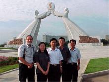 Dr. Yousry Abushady and an inspector of the IAEA with DPRK guides in front of the Reunification Statue in North Korea. (Credit: IAEA) 