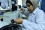 A lab technician prepares sample slides for analysis at the KHCC laboratory, which helps to assess if a patient requires radiation diagnosis and treatment.