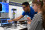 A Radiation Safety Technician demonstrates how a type of radioactive material that emits alpha particles interacts with other materials. The detector picks up these interactions and displays them as glowing pulses on a screen. On the table, there are pieces of different materials that can be placed between the radioactive source and the detector. These materials vary in thickness and type, from something as light as paper to something heavy like lead, to show how well they block or reduce the radiation. 