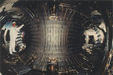 Internal view of the TORE SUPRA (today WEST), the first large tokamak to operate with a superconducting toroidal magnet vacuum chamber.  
On the inner side (in the centre picture) carbon tiles brazed on cooled stainless steel tubes act as a toroidal bumper limiter.  
On the outer side (L and R) one can see 2 ergodic divertor coils.
(IAEA Archives/Credit: CEA, France)