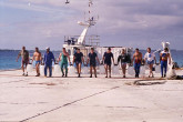 Members of an international team, working on a two-year study of radioactivity at the Mururoa and Fanfataufa Atolls, shown with a collection of ocean water for sampling. 1996. Please credit IAEA/ MOUCHKIN Vadim