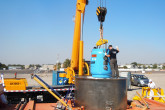 Inserting the Skoda VPVR/M spent fuel shipment container into the lower part of the TUK-145/C over-package. This over-package, made of titanium, meets the more stringent criteria necessary for air transport. It protects its content from extreme shocks, such as one associated with a plane crash. (Photo: S. Tozser/IAEA)