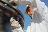 Putting in the final screws to hold together the top and bottom halves of the TUK-145/C over-package. (Photo: S. Tozser/IAEA)