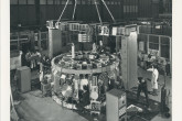 The DITE tokamak during final stages of construction at Culham Laboratory. 
The device was used for studies of the heating and confinement of high temperature plasma for fusion research. 
Two methods were used for heating the plasma confined in the toroidal vacuum chamber; first by passing a large current (200,000 Amps) through the plasma and secondly by the injection of energetic neutral atoms. 
The current, induced in the plasma by transformer action, also provided one of the confining magnetic fields; the second field was provided by a set of liquid nitrogen-cooled coils encircling the torus. 
The device was also be used to study the extraction of impurity atoms from the plasma using a magnetic divertor.
(IAEA Archives/Credit: UKAEA, United Kingdom)

