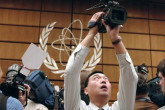A cameraman jostles for best position to capture events at a photo opportunity inside the IAEA Board room. The meeting is closed to the press. (Photo Credit: D. Calma/IAEA)