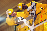 An inspector fixes a surveillance camera that has been mounted high in a nuclear reactor hall in order to record the activities taking place below.