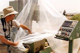 IAEA Action Team Inspector uncovers a CNC machine tool, used to manufacture centrifuge components. Photo Credits: Action Team 1991-1998/IAEA