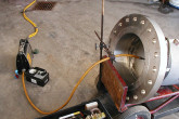 Industrial radiography uses ionizing radiation to view objects in a way that cannot be seen otherwise.  Here welders use a radiography device to take images of a weld made on a pipe flange. <br /><br />(Photo: ETI Ewer Testing and Inspection)