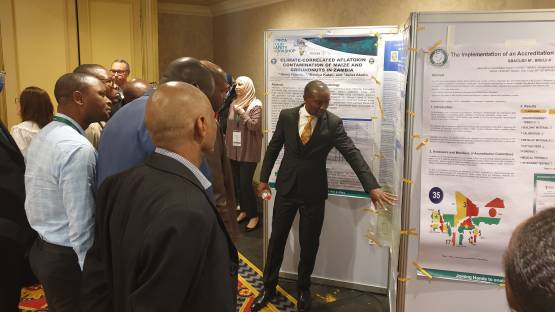 A participant presenting his poster on the impact of climate change on mycotoxins and laboratory accreditation at the African Food Safety Workshop, jointly held by the IAEA and the FAO in Johannesburg, 27 June–1 July 2022. (Photo: J. Sasanya/IAEA